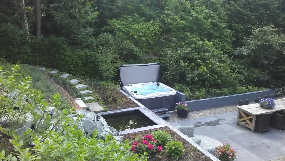 PassionSpa Pleasure-spabad – grå og sort, låg, blåt vand, terrasse, grønne omgivelser PassionSpa Pleasure-spabad – grå og sort, låg, blåt vand, terrasse, grønne omgivelser