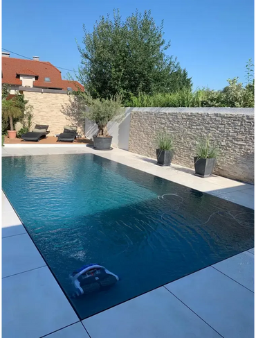 Pooltime Exclusive blåvit robotisk poolrengörare i kristallklar turkos overflow pp pool