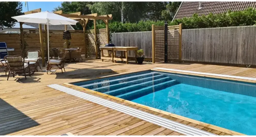 Pooltime Exklusiv 12mm rektangulär pool med klart blått vatten och vita kakelkanter i trädeck