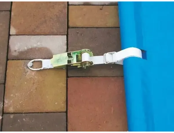 Grön och vit ratchetkabel säkrar blå pooltäckning inkl handenhet