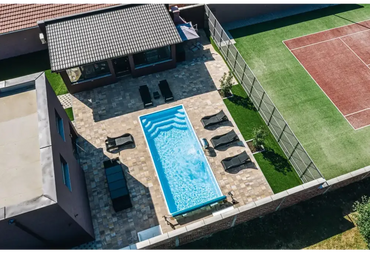 Aruba-glasfiberpool – blå overflade, rektangulær form, flisekanter, bølger i vandet