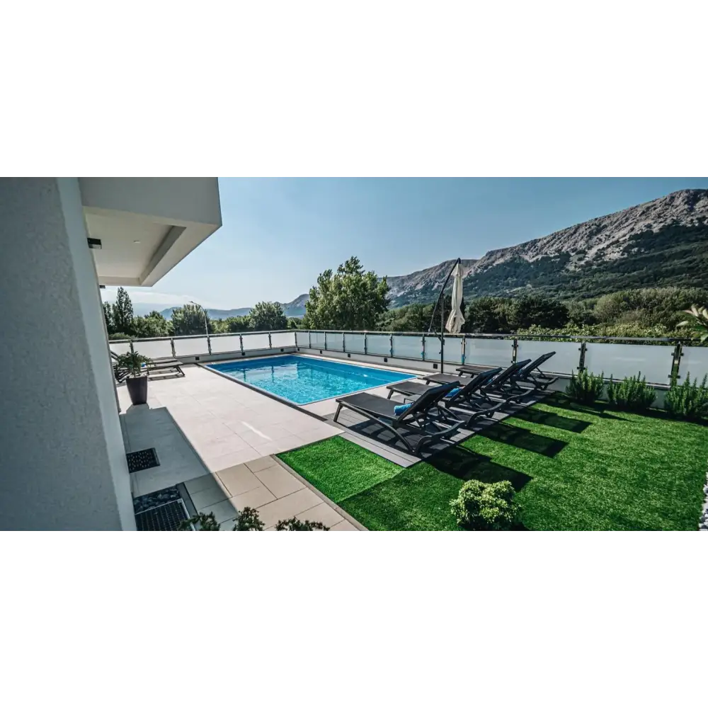 Rektangulär blå glasfiberpool Aruba 700 med klart vatten och kakelkanter