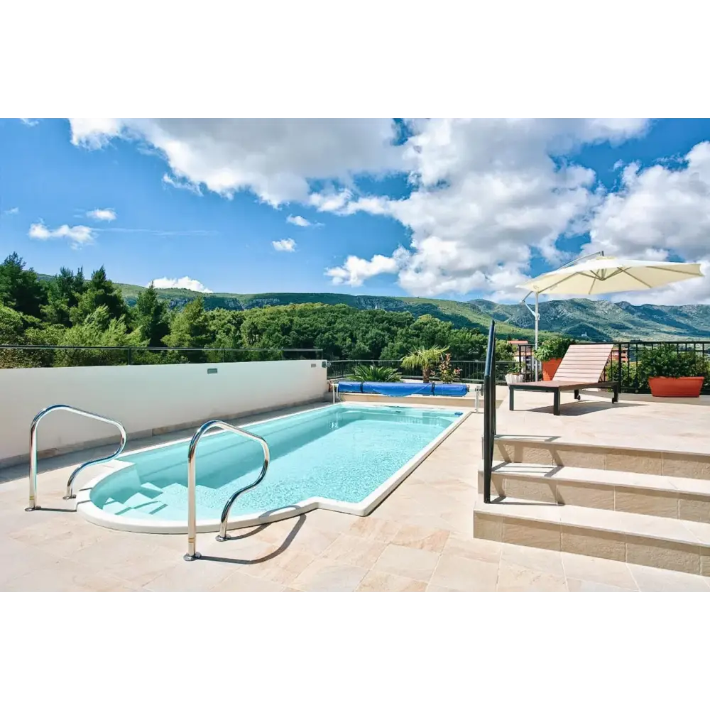 Glasfiberpool Aves med avrundad trappa och kaklad omgivning i klarblått vatten