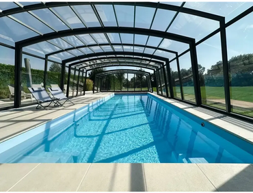 Bahama-havepool med transparent pooltag – langstrakt form, rektangulær form, indendørs, klart blåt vand, sort ramme, tag med klare paneler