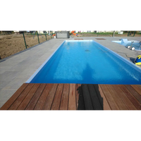 Glasfiberpool Bahama 11 med klarblått vatten och vit insats, grå stenplattor och brun trädeck