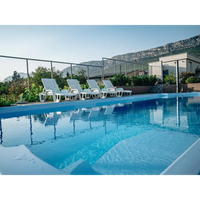 Vita plastfåtöljer vid Glasfiberpool Barbados med pooltak för speciella evenemang