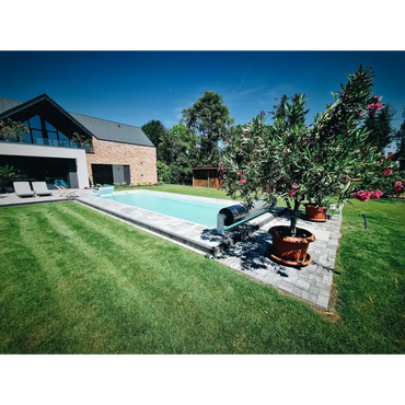 Glasfiberpool Jamaika rektangulär pool med klart blått vatten och gräsmatta