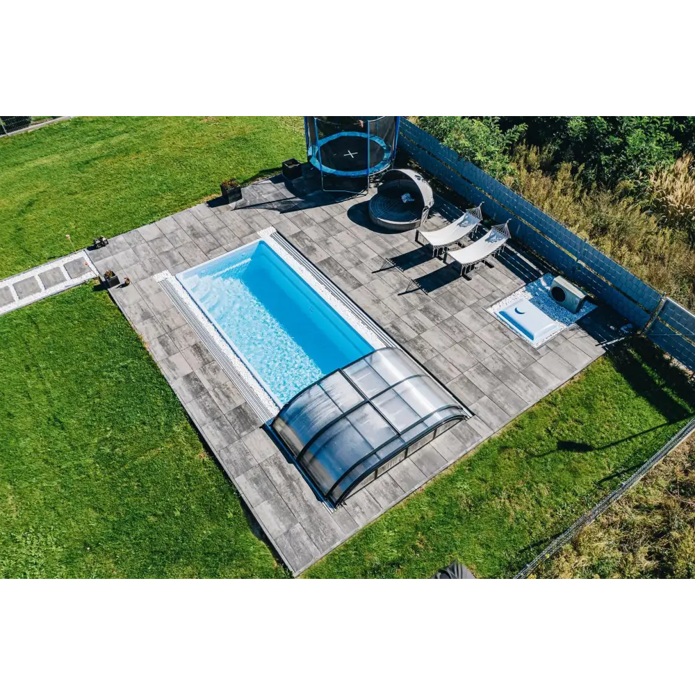 Glasfiberpool Papeete 6x3x1,5 m med blåvatten, grå stenplattor och pooltak