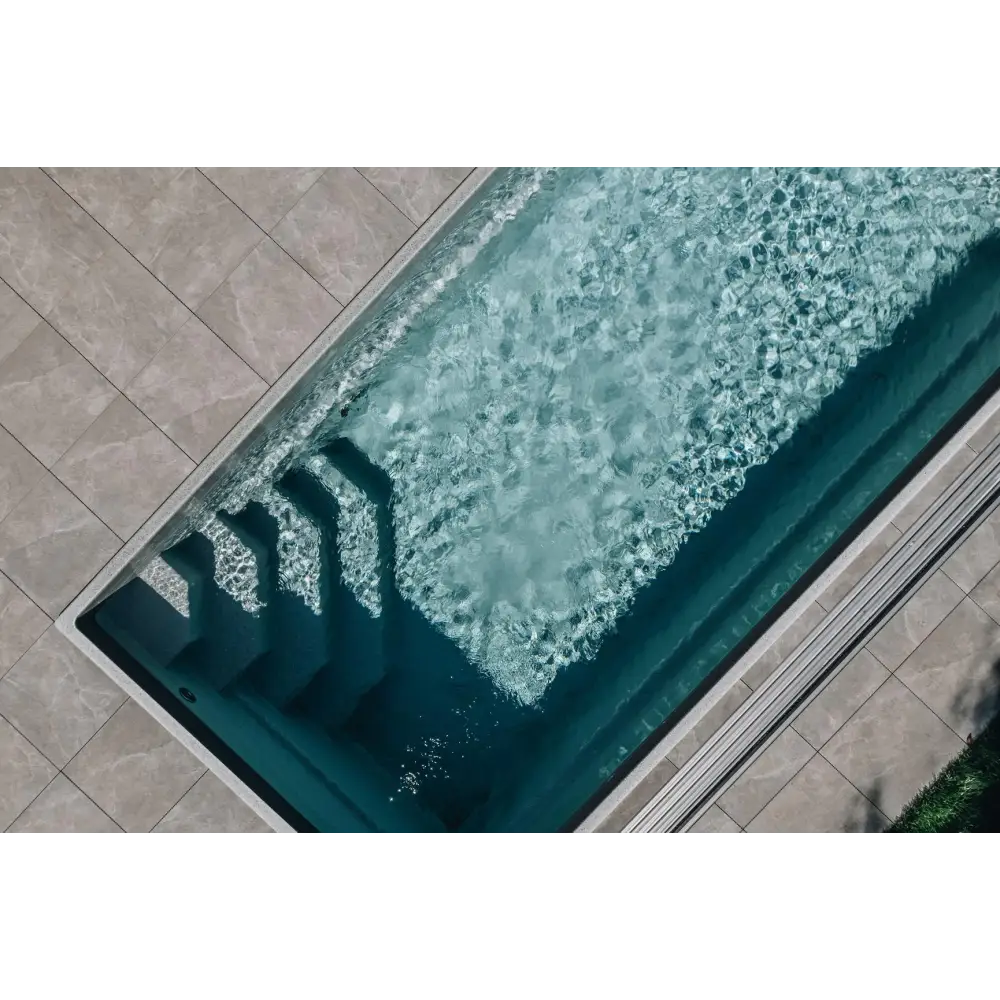 Glasfiberpool Saba med klart blått vatten och vita kaklade kanter