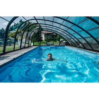 Kvinna simmar i klarblå Glasfiberpool Trinidad 9,70m x 3,70m x 1,60m under valvformad glastak