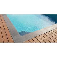 Klar blå poolvatten med grå stenplattor och trädäck i Natura Kiruna paket