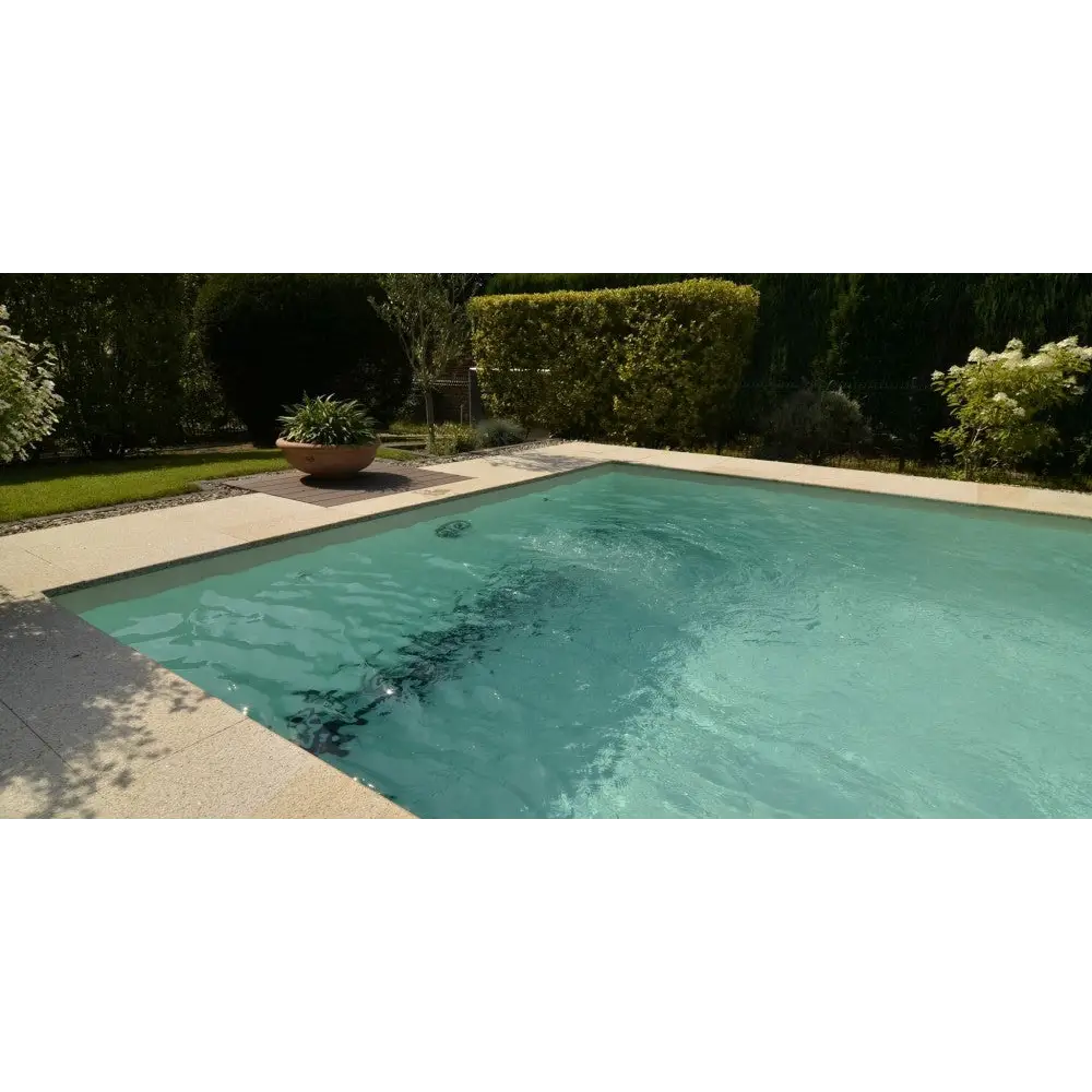 Rektangulär pool med turkost vatten, beige stenkanter och Natura Kiruna paket