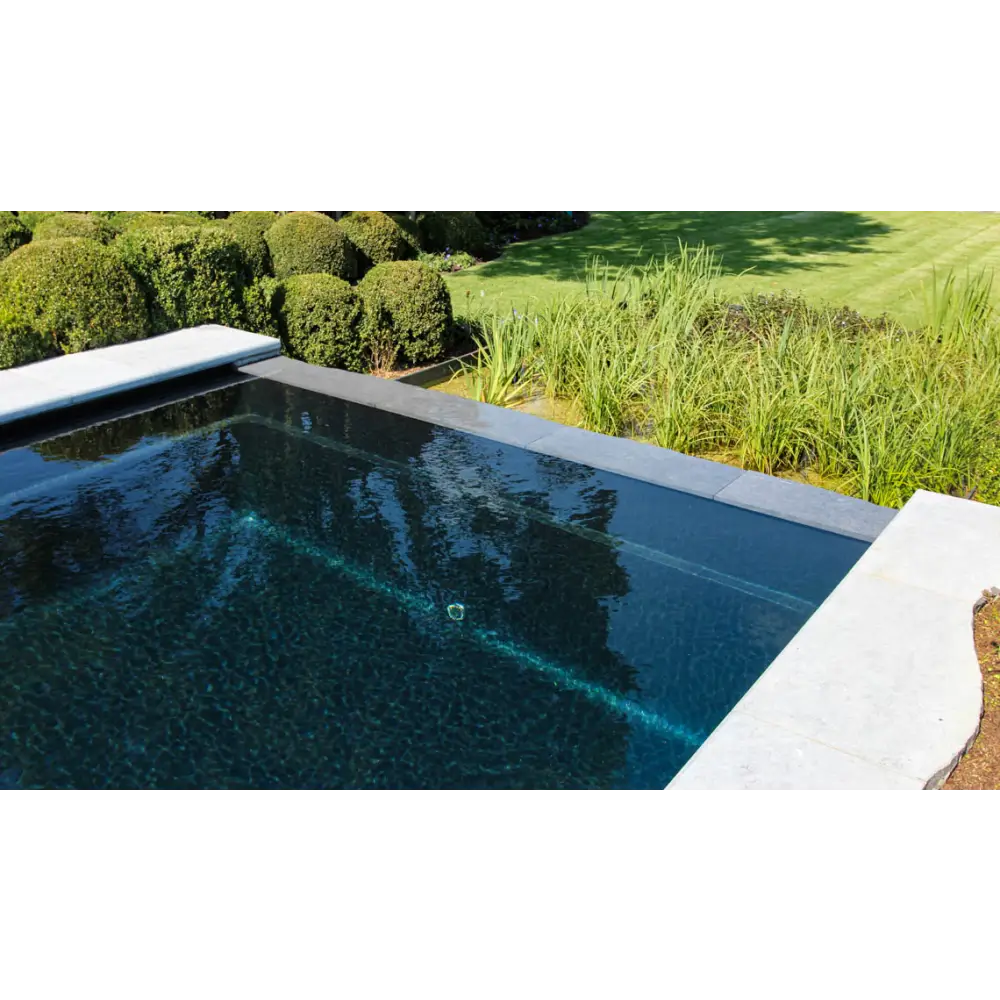 Rektangulär infinitypool Leisurepools Cube i modern design med mörkblått vatten