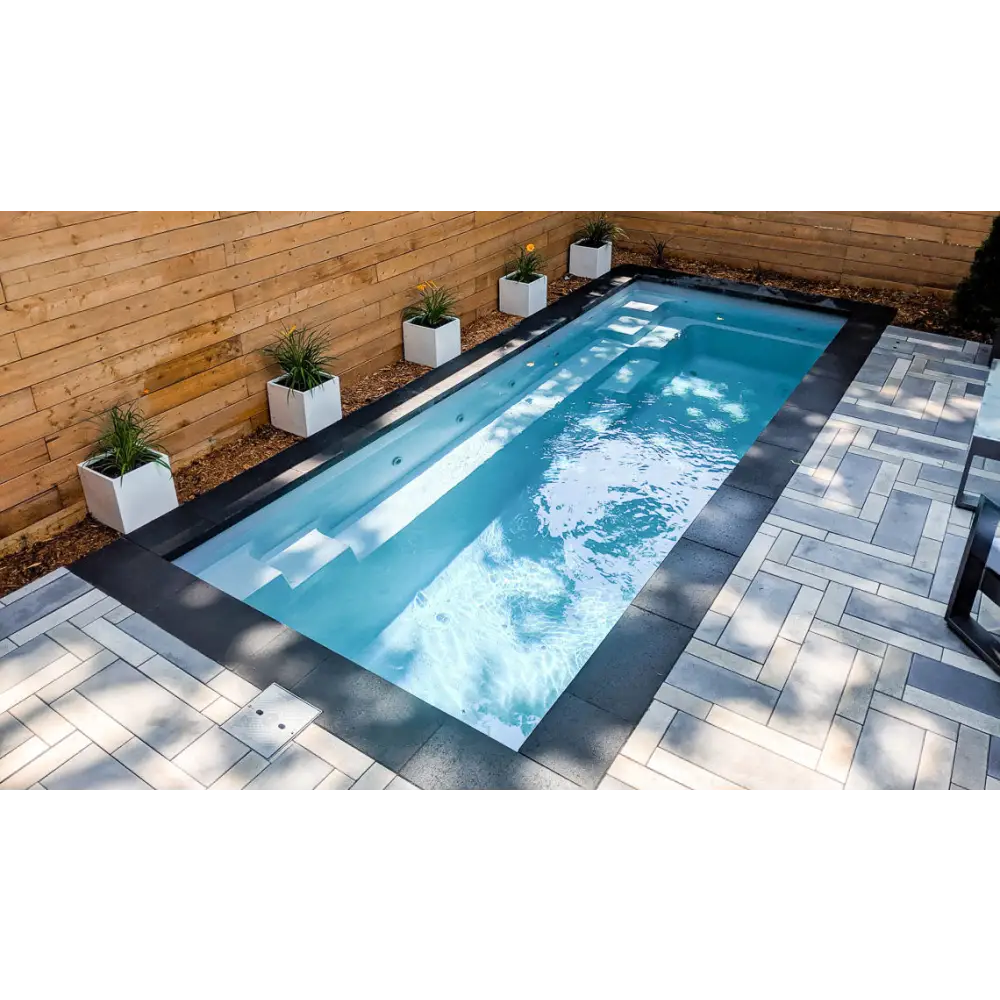 Leisurepools Espirit med slimmad form för trängre utrymmen, rektangulär pool med klart blått vatten och svarta kakelkanter