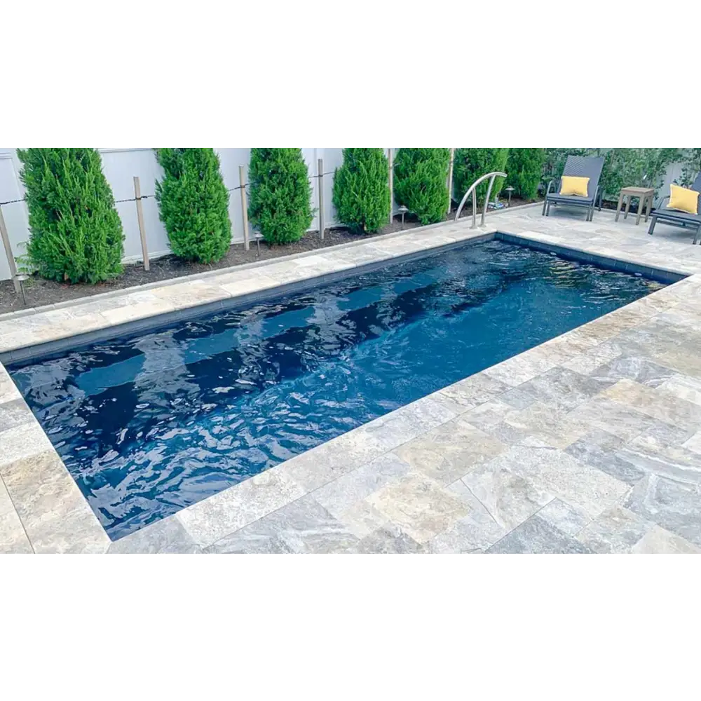 Rektangulär Leisurepools Harmony pool med klart blått vatten, grå sten och buskar