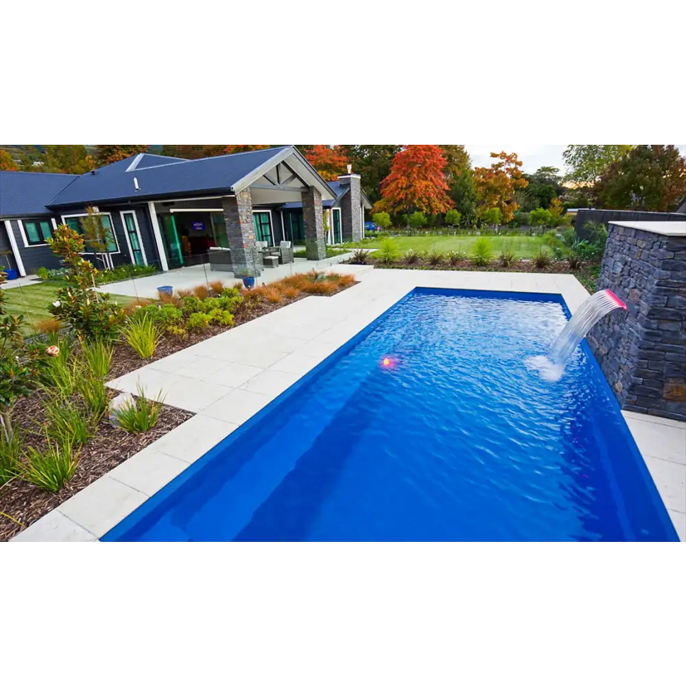 Vibrant blå rektangulär Leisurepools Harmony pool med stenfall och klart vatten