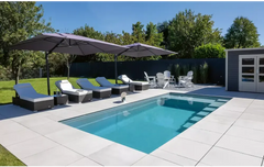 Rektangulær pool – høj vandlinje, visuelt imponerende design, loungestole i rattan