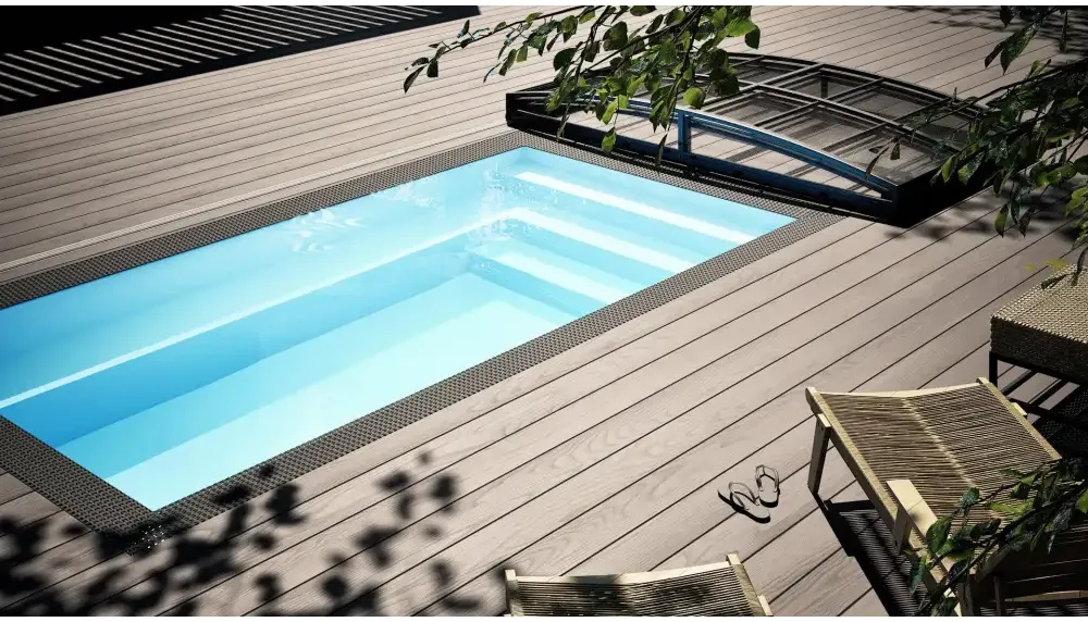 Rektangulär minipool wellness pool med klart blått vatten och svart kakelkant i trädeck