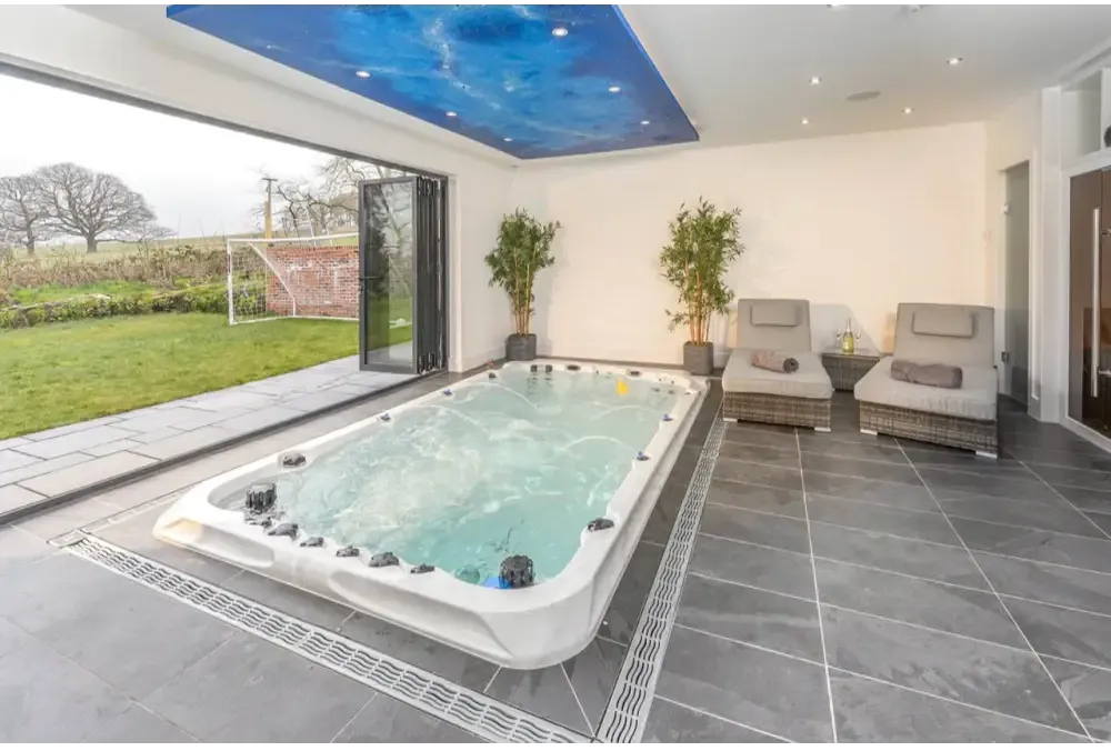 PassionSpa Activity 2 Deep-swimspa – Sport Collection, hvid overflade, rektangulær form, sorte massagedyser, turkisblåt vand