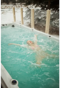 PassionSpa Activity 2-swimspa – kvinde i pink bikini flyder roligt omgivet af sne