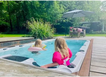 PassionSpa Aquatic 1-swimspa – hvid overflade, børn i boblebadet, træterrasse