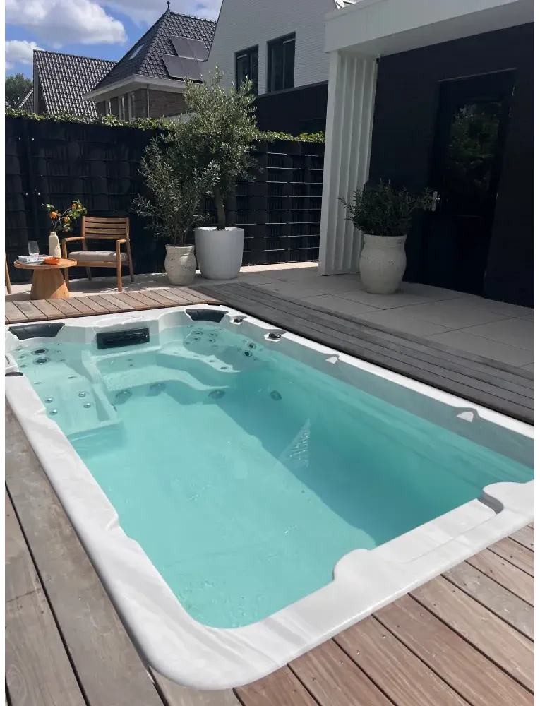PassionSpa Aquatic 1-swimspa – Sport Collection, hvid overflade, rektangulær form, turkisblåt vand, indbyggede massagedyser, træterrasse