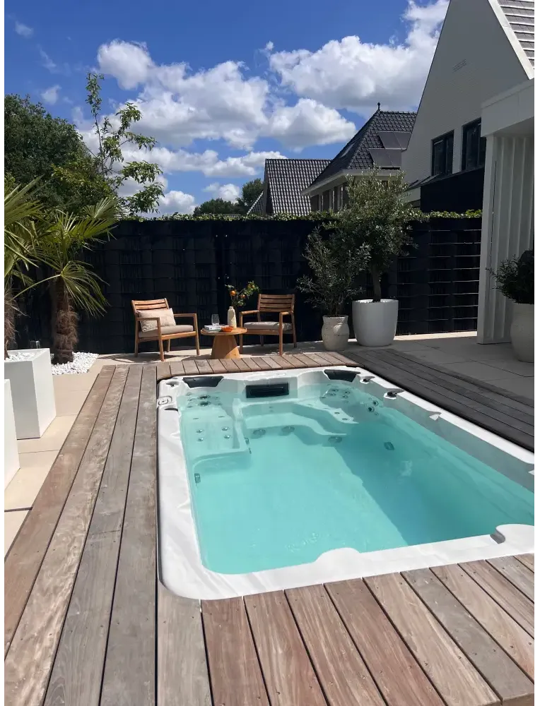 PassionSpa Aquatic 1-swimspa – Sport Collection, hvid overflade, rektangulær form, turkisblåt vand, massagedyser, træterrasse
