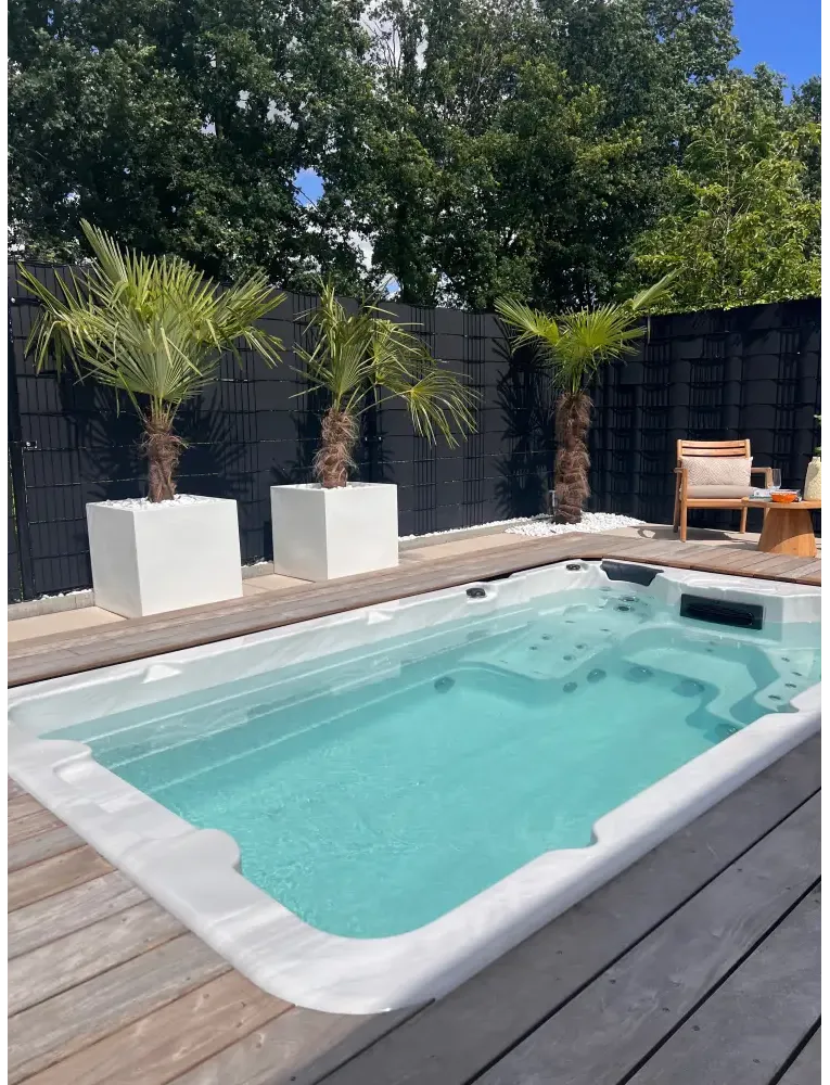 PassionSpa Aquatic 1-swimspa – Sport Collection, hvid overflade, rektangulær form, turkisblåt vand, indbyggede massagedyser, træterrasse