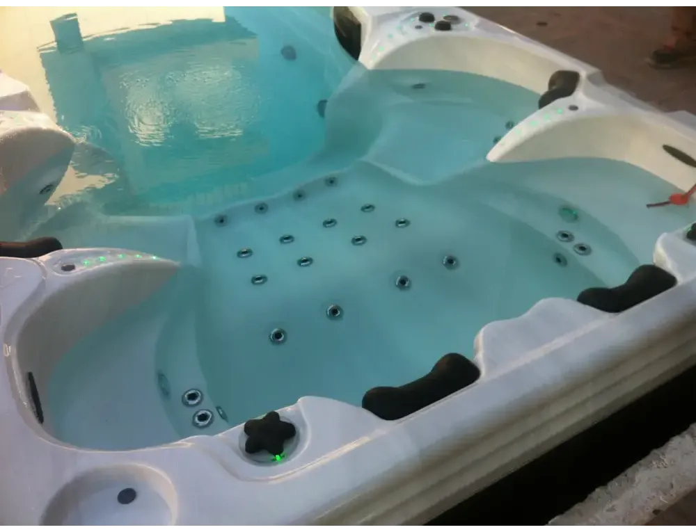 PassionSpa Aquatic 6-swimspa – hvid overflade, hvid inderside, sorte stjernegreb, blåt vand