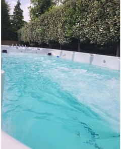 PassionSpa Spirit-swimspa – hvid overflade, turkisblåt vand, massagedyser, grønne træer