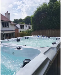 PassionSpa Vitality-swimspa – stilfuldt design, lysegrå overflade, boblende vand, turkisblåt vand, sorte massagedyser