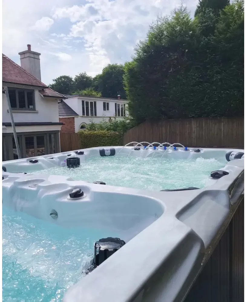 PassionSpa Vitality-swimspa – stilfuldt design, lysegrå overflade, boblende vand, turkisblåt vand, sorte massagedyser
