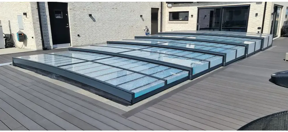 Icon Kit-pooltag – moderne design med transparente paneler, sort ramme, over en træterrasse