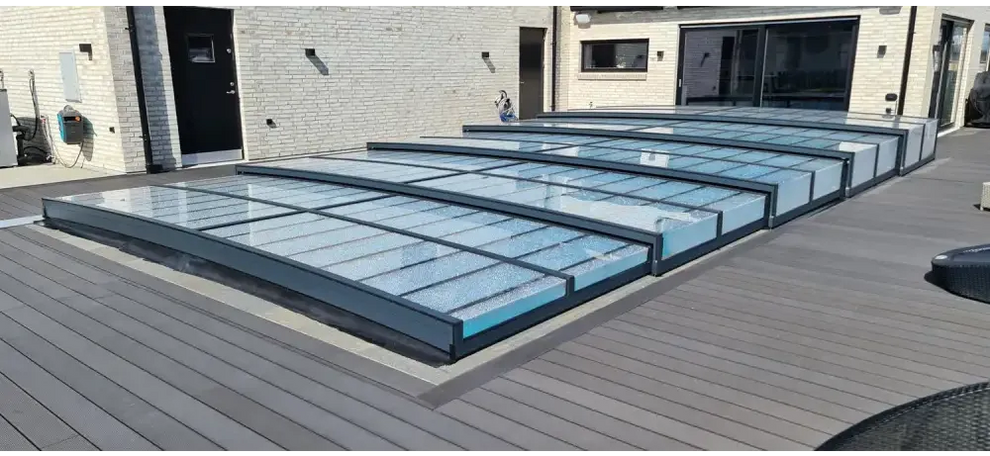 Icon Kit-pooltag – moderne design med transparente paneler, sort ramme, over en træterrasse