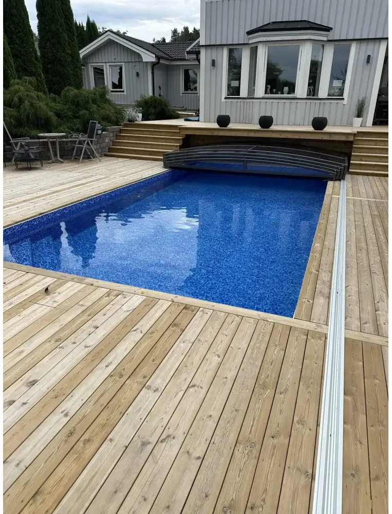Elegant pooltak Sydney med blå mosaik, trädeck och grå cover ger flexibilitet