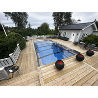 Pooltak Sydney 3.5×4.2 med enkelskena i antracit, rektangulär pool med glasöverdrag och blåvatten på trädeck omgiven av utemöbler och grön