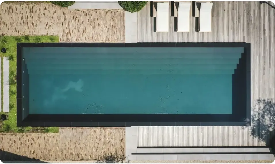 Rektangulär infinitypool ovanmark PP med 20mm skimmer, djup tealvatten och svarta kakelkanter
