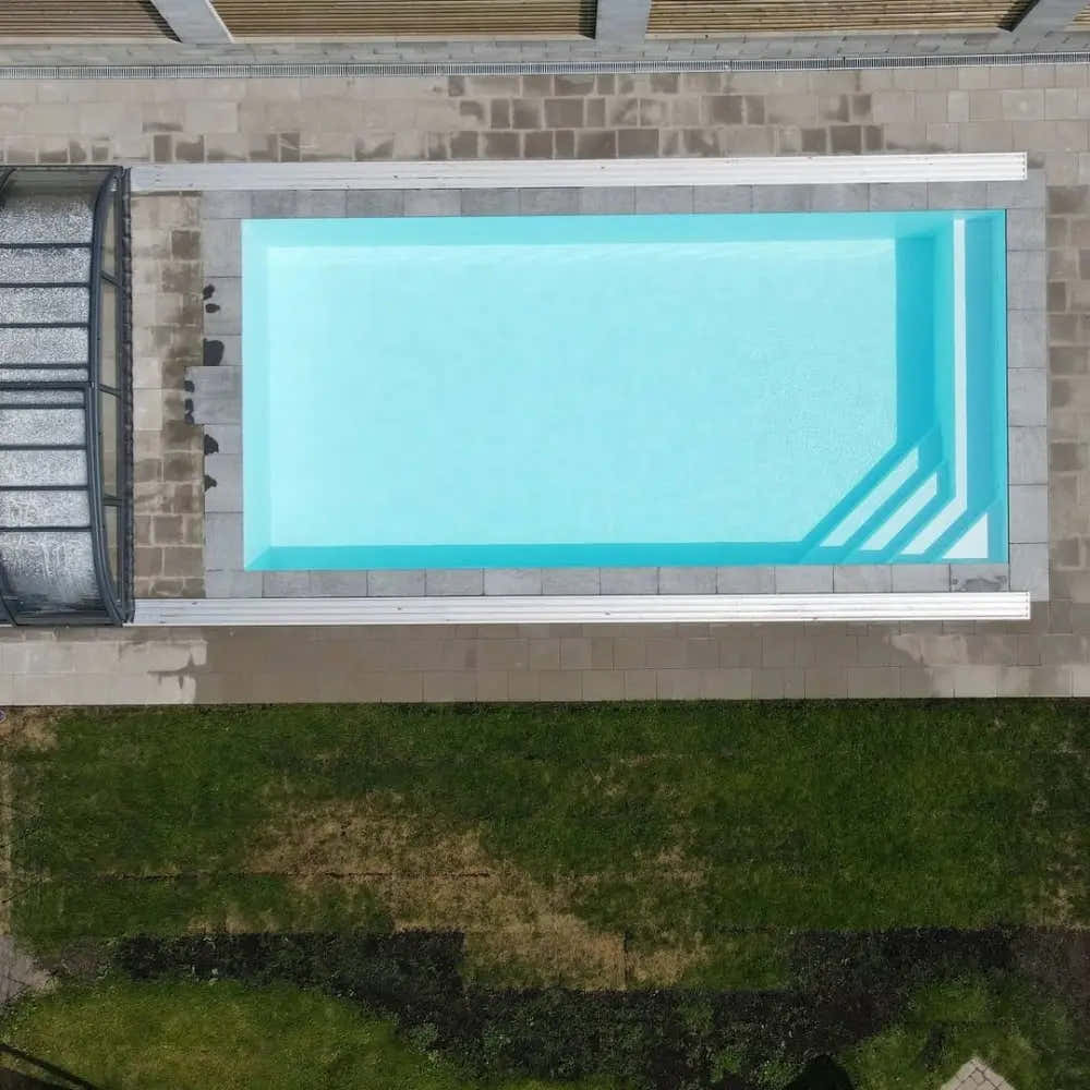 Pooltime Exclusive-pool, 12 mm – rektangulær form, turkisblåt vand, hvide fliser omkring poolen