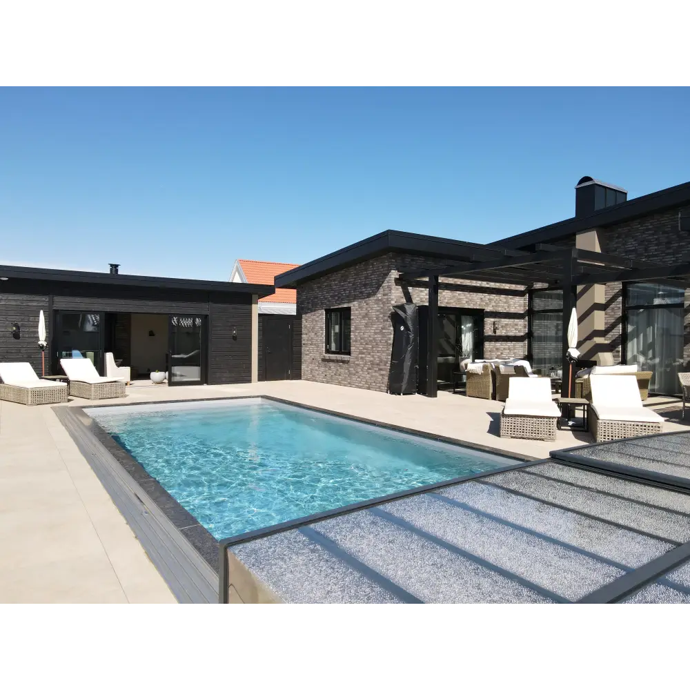 Rektangulär pooltime exklusiv 12mm pp pool 3 x 6 x 1,5 m med klarblått vatten och mörkgrå kaklade kanter vid ljusbeige patioarea för att köpa pool eller pooltak