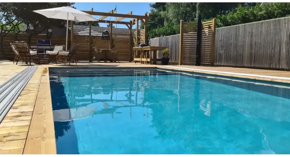 Pooltime Exklusiv 12mm rektangulär pool med klart blått vatten och trädäck