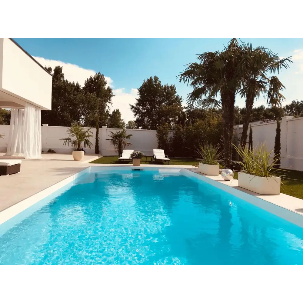 Klar turkost pool exklusiv 4x8x1,5 m med vita kakelkanter och modern möbel