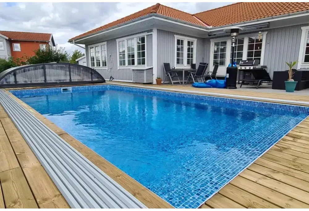 Inbyggd rektangulär pool med blå mosaik och trädäck – Thermopool Standard Plus