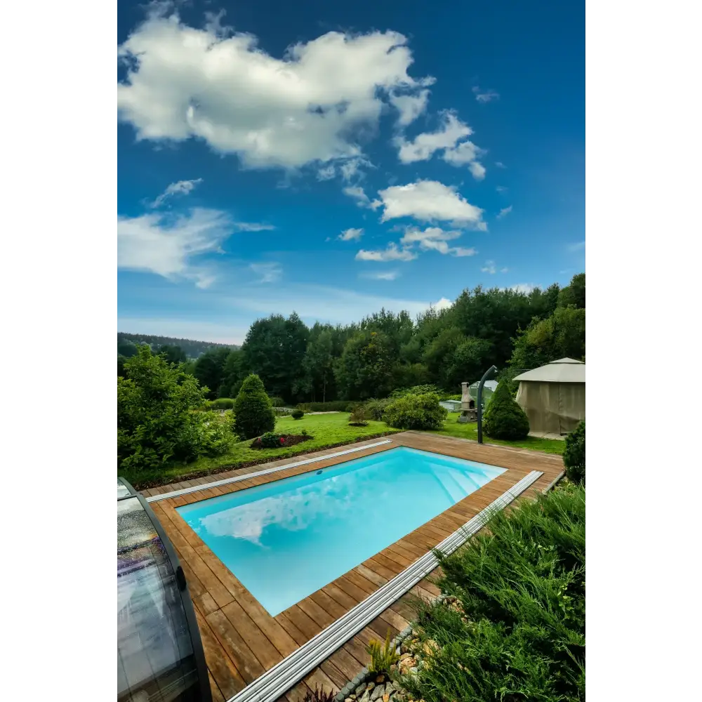 Rektangulär Thermopp Poolpaket Qbig med klart blått vatten, trädeck och grönska